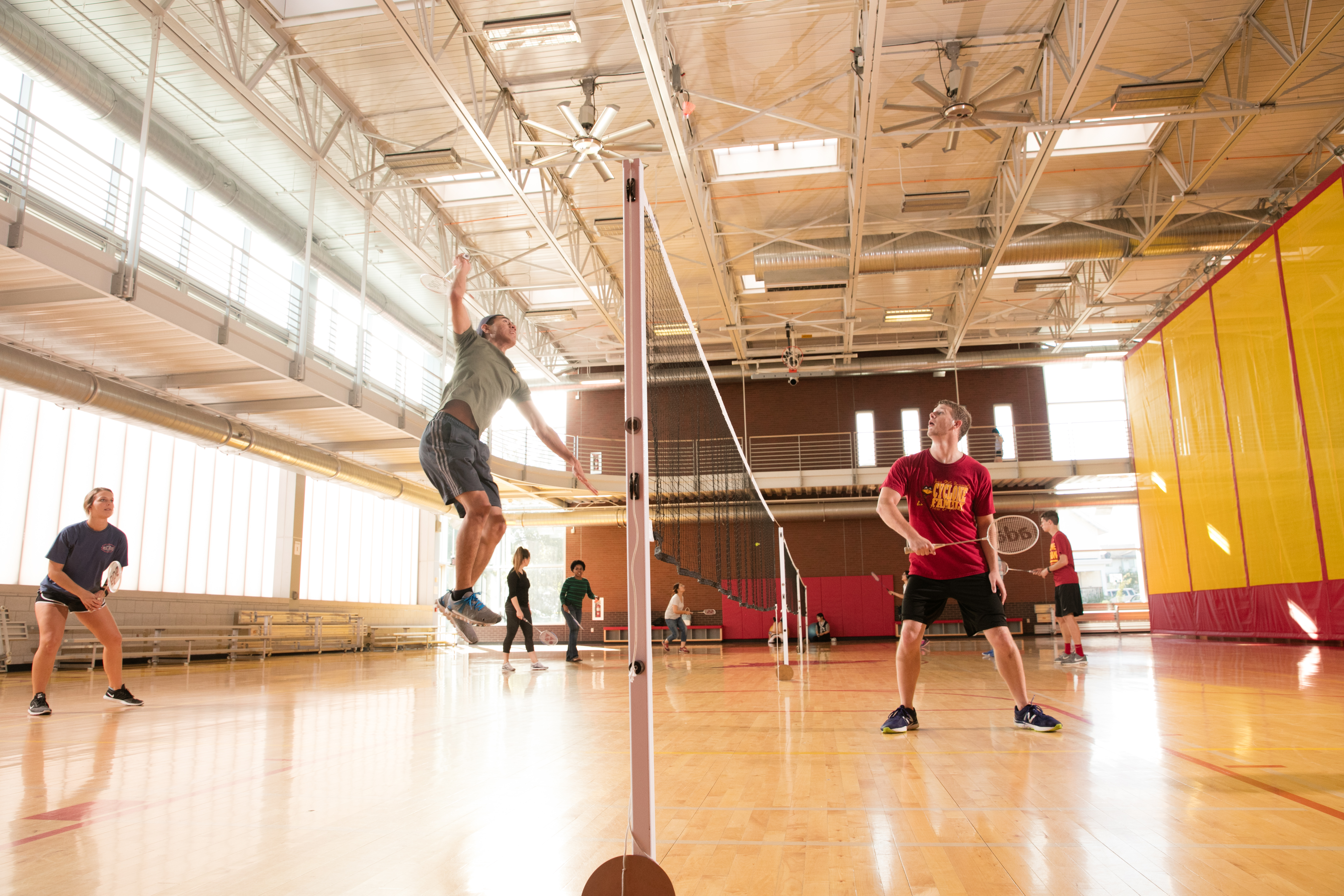 a photo of students playing badminton at state gym